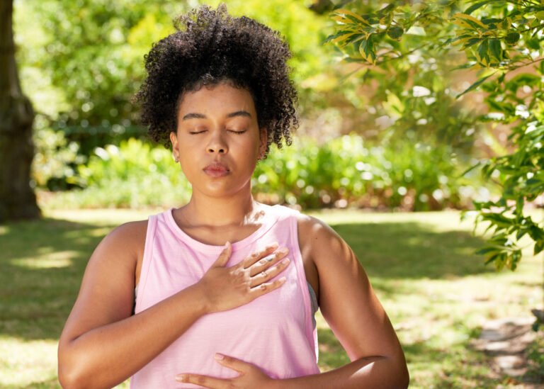 Person meditating peacefully outdoors to relieve stress